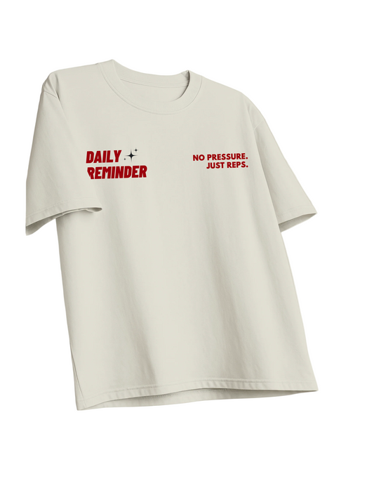 Off White t-shirt with red text 'DAILY REMINDER NO PRESSURE. JUST REPS.' on a white background